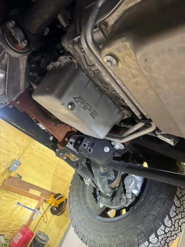 An aftermarket deep oil pan installed under a truck